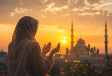 امرأة ترفع يديها بالدعاء وقت غروب الشمس أمام مسجد في أجواء روحانية هادئة يوم الجمعة.